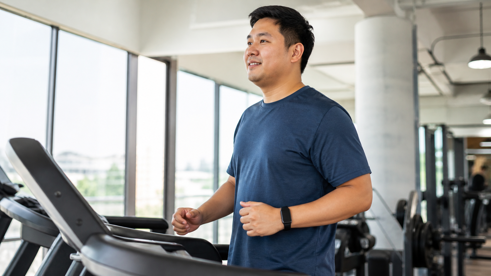 Beginner walking on a treadmill while wearing a generic fitness watch
